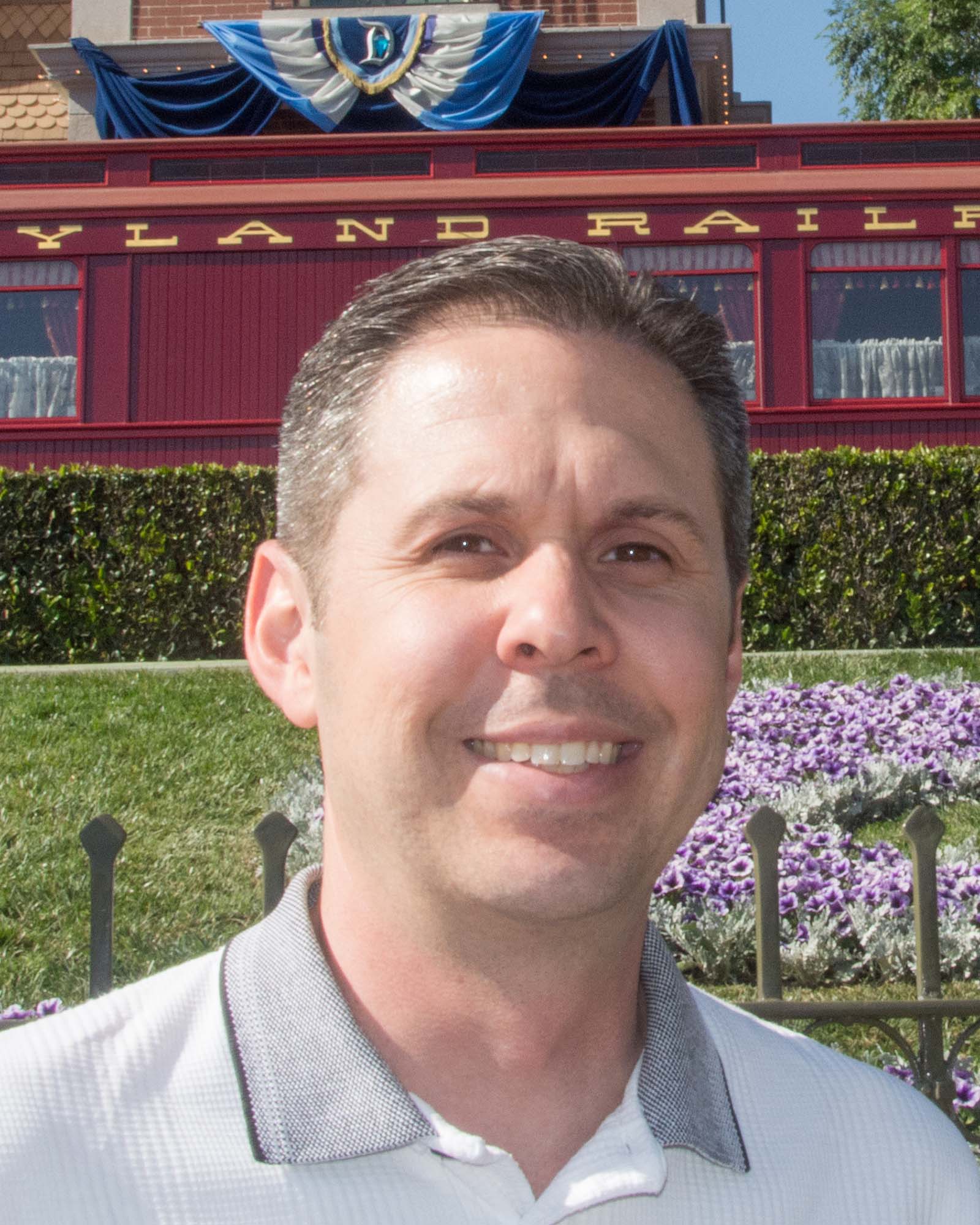 Headshot of Jeff Whitfill, owner of E-Ticket Travel standing in front of the Disneyland Railroad Station